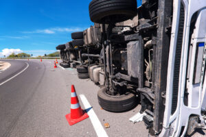 An 18-wheeler on its side from an accident with orange cones around it in El Paso.