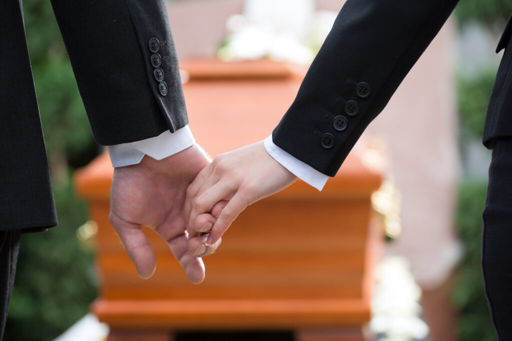 Two family members mourn at the funeral of a loved one who was the victim of a wrongful death 