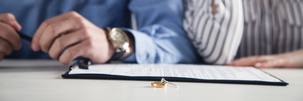 Couple with divorce contract and ring on desk. Divorce