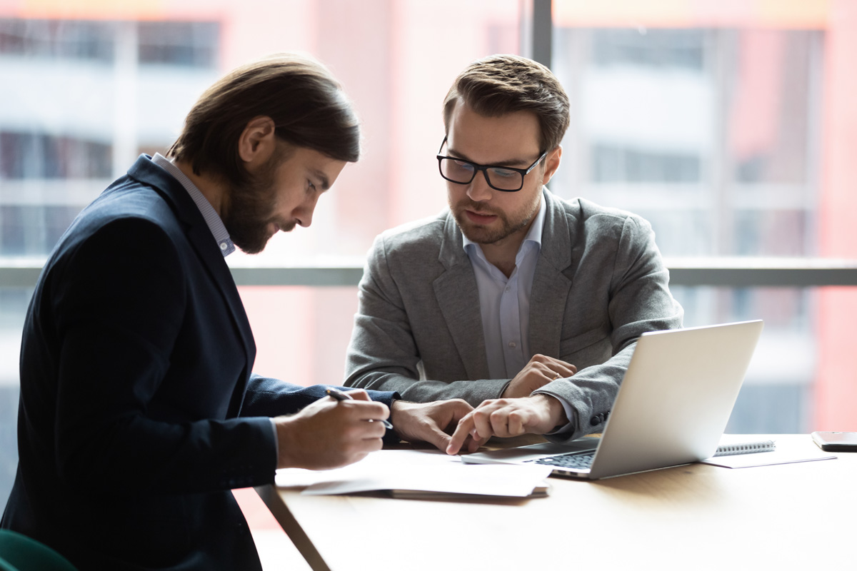 A personal injury lawyer in El Paso consulting with a client and reviewing paperwork at a desk.